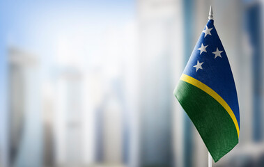 A small flag of Solomon Islands on the background of a blurred background