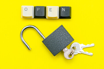 an open lock with keys on a yellow background the word open concept is laid out on top of a computer keyboard