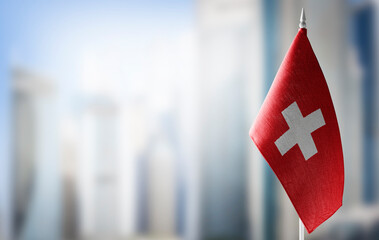 A small flag of Switzerland on the background of a blurred background