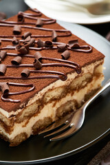 Portion of Traditional Italian Tiramisu dessert and cup of coffee on grey concrete background