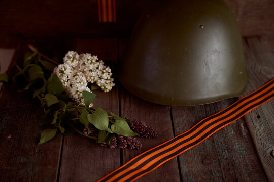 Blossomed cherry blossoms with a soldier's helmet and St. George ribbon. Photo by May 9. Victory Day