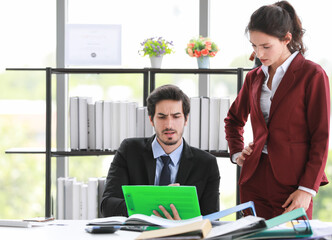 Colleagues discussing documents in office