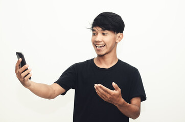 Asian man wearing a casual black shirt pointing at his cellphone