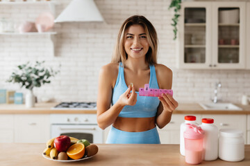 Cheerful lady holding a container with vitamins and smiling