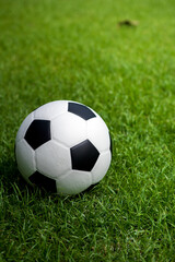Fototapeta premium Football placed on a grass pitch in the afternoon awaiting for teams practicing or matches in a tournament.