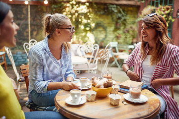 A group of female students are shocked by their female friend's story while having a drink in a bar garden. Leisure, bar, friendship, outdoor