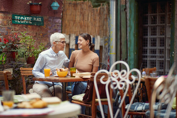 An older woman and her young female friend having a conversation while they have a drink in the bar. Leisure, bar, friendship, outdoor