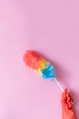 hand with a brush on a pink background, cleaning