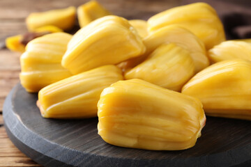 Delicious exotic jackfruit bulbs on wooden table, closeup