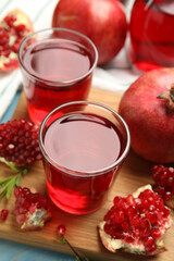 Pomegranate juice and fresh fruits on light blue wooden table