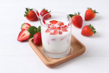 Delicious drink with strawberries on white wooden table