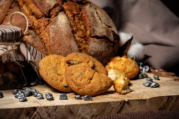 Pieces of broken biscuits lie on a wooden stump next to bread