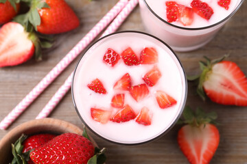 Tasty drink with strawberries on wooden table, flat lay