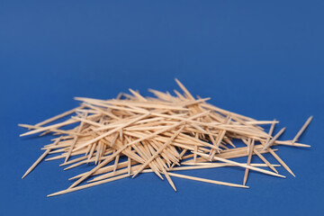 Pile of wooden toothpicks on blue background