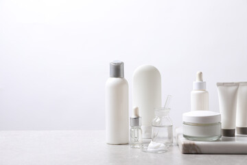 Fototapeta na wymiar Organic cosmetic products and laboratory glassware on white table, space for text