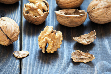 Walnuts lie on a dark wooden table.