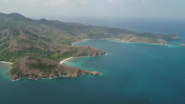 Aerial view coastline with tropical beach, island Limbones, lagoons and coral reefs. Neela cove, Philippines, Luzon. Coast ocean with turquoise water. Tropical landscape in Asia.