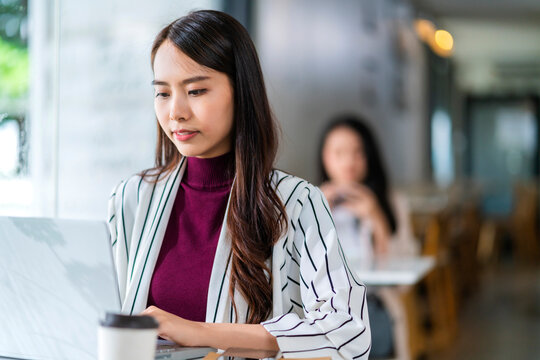 young attractive asian female wear casual cloth hand use smartphone and laptop device comminication social contact in cafe restaruant sit at counter next to big window daylight