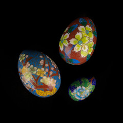 set of wooden Easter eggs with floral patterns on isolated black background