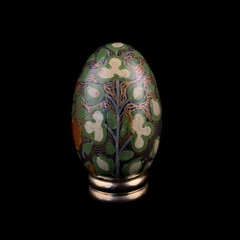 wooden Easter egg with floral patterns on isolated black background