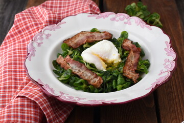 Poached egg salad with nuts and bacon