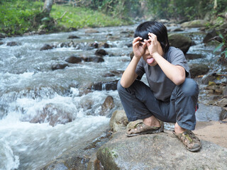 Asian boy feel relax at waterfall