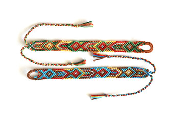 DIY friendship bracelets with Indian colorful pattern handmade of thread on white background