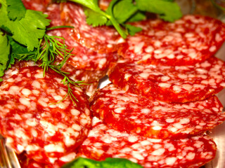 salami sausage with herbs on the festive table is sliced