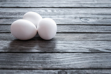 White chicken eggs on wooden table, copy space