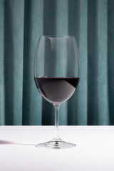Wine glass and on a white table on a curtain background