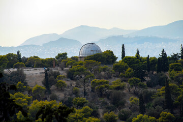 Athens, Greece. The old telescope of the National Observatory of Athens in Pnyx area on top of the Nymphs' Hill in Thiseio. View from the Areopagus Hill in Plaka under the Acropolis of Athens city