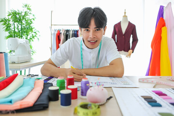 Young Asian man holding pencil and drawing model sketch at desk in atelier