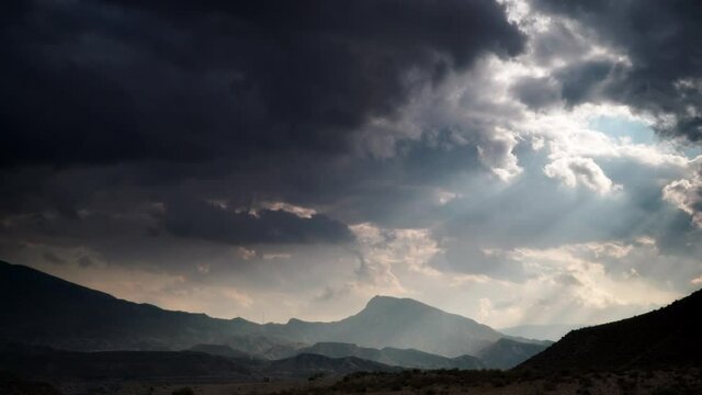 Time lapse of dark stormy clouds moving over Tabernas desert, mountain landscape in Almeria, Spain.
