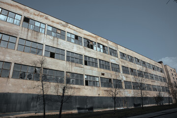 Large abandoned factory. The facade of an abandoned factory with broken windows