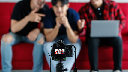 Camera shooting male bloggers on sofa