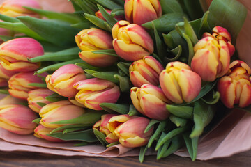 Fototapeta premium A large bouquet of spring tulips in pink paper wrapping. 