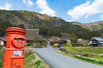 Fototapeta na wymiar An old house with a red mailbox and thatched roof in Kitamura, Miyama Kayabuki no Sato, Nantan City, Kyoto Prefecture, Japan