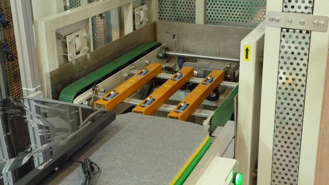The computer case moves along a conveyor belt and is loaded into an elevator.