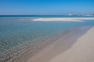 Sabbia bianca con mare trasparente e cielo azzurro.