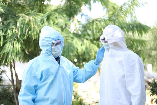 Two health workers in hazmat suits encouraging one another in the midst of Covid-19 pandemic