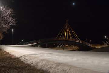 Fototapeta na wymiar Ski track on the background of the suspension bridge on a winter evening.