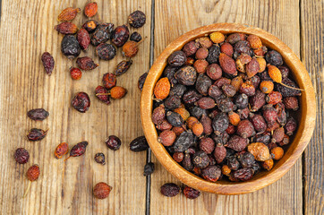 Dried rose hips in wooden bowl, natural vitamin C.