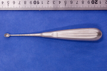 bone curette on a blue background