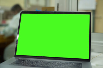 Laptop with green sreen in office.