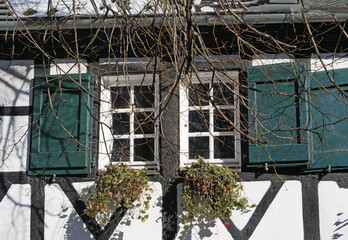 Close-up of a window with green shutters of a traditional framed house with windows boxes in Hilden, Germany, Europe
