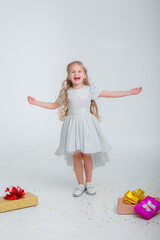 little girl in birthday hat catches confetti on white background studio