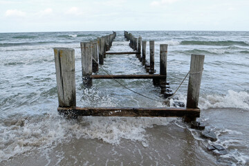 Slipway with wooden piles in the rough sea on a windy day; Zingst, Baltic Sea, Germany, Europe
