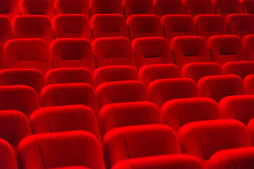Naklejka premium empty red velvet seats in cinema auditorium