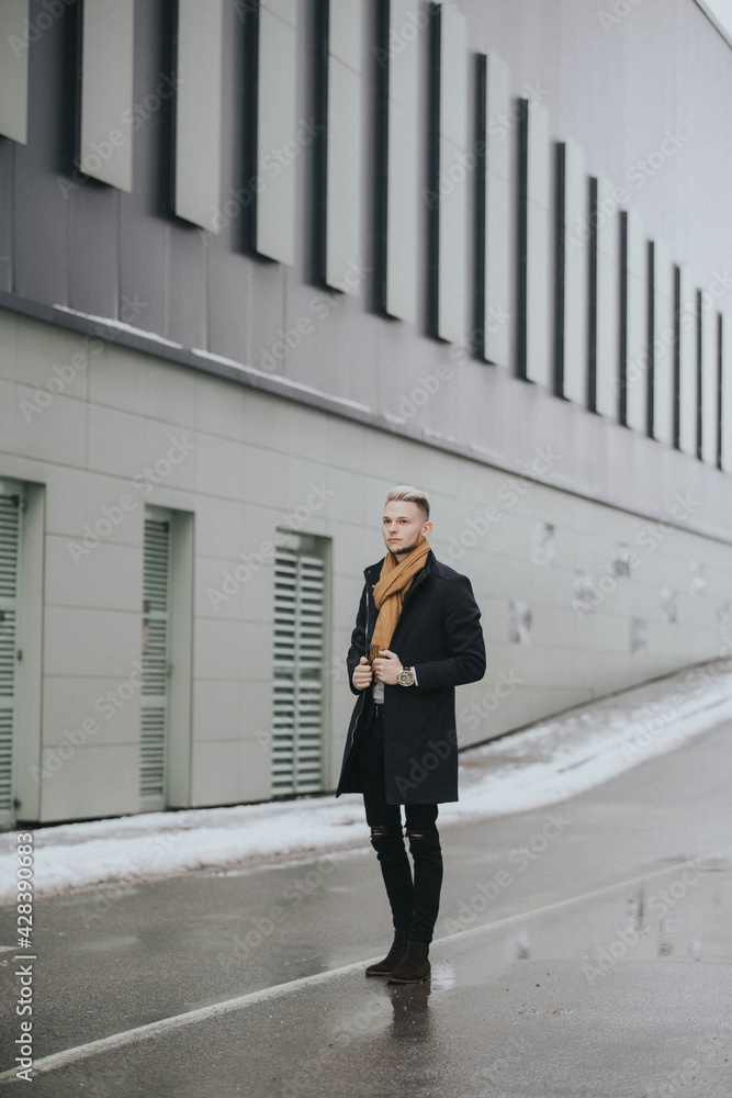 Canvas Prints vertical shot of a caucasian stylish male posing outdoors in a snowy city