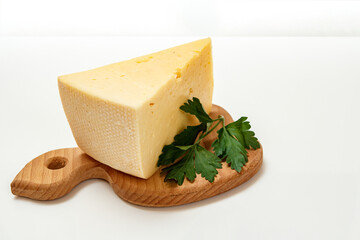 Cheese and parsley on wooden cutting board on white background